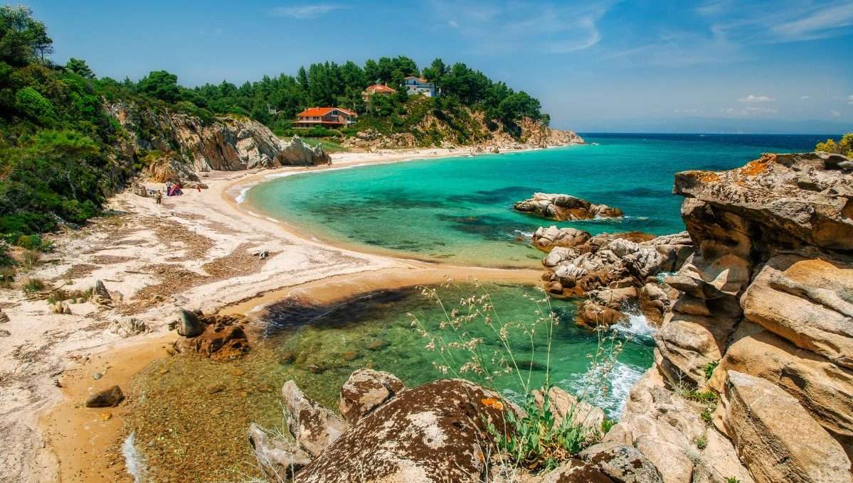 חוף בתולי עם מי טורקיז וצוקי סלע בסיתוניה (Sithonia), חלקידיקי (Chalkidiki), יוון.