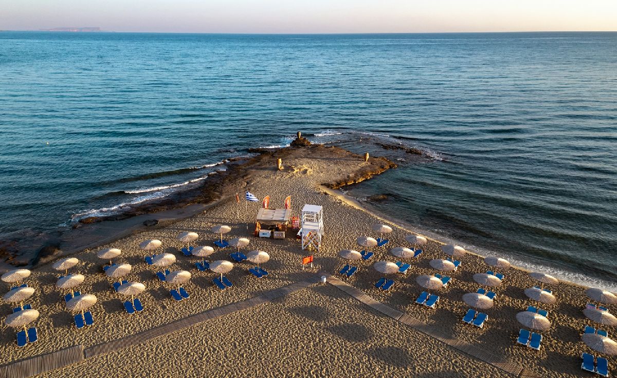 חוף פרטי של מלון מפואר ביוון, עם שמשיות ומים צלולים