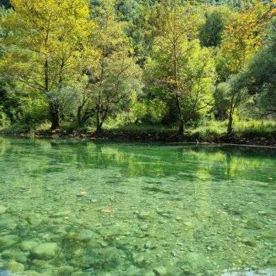 נהר הוידומטיס (Voidomatis River) עם מים צלולים בגוון טורקיז-ירקרק בלב חבל זגוריה (Zagori), יוון.