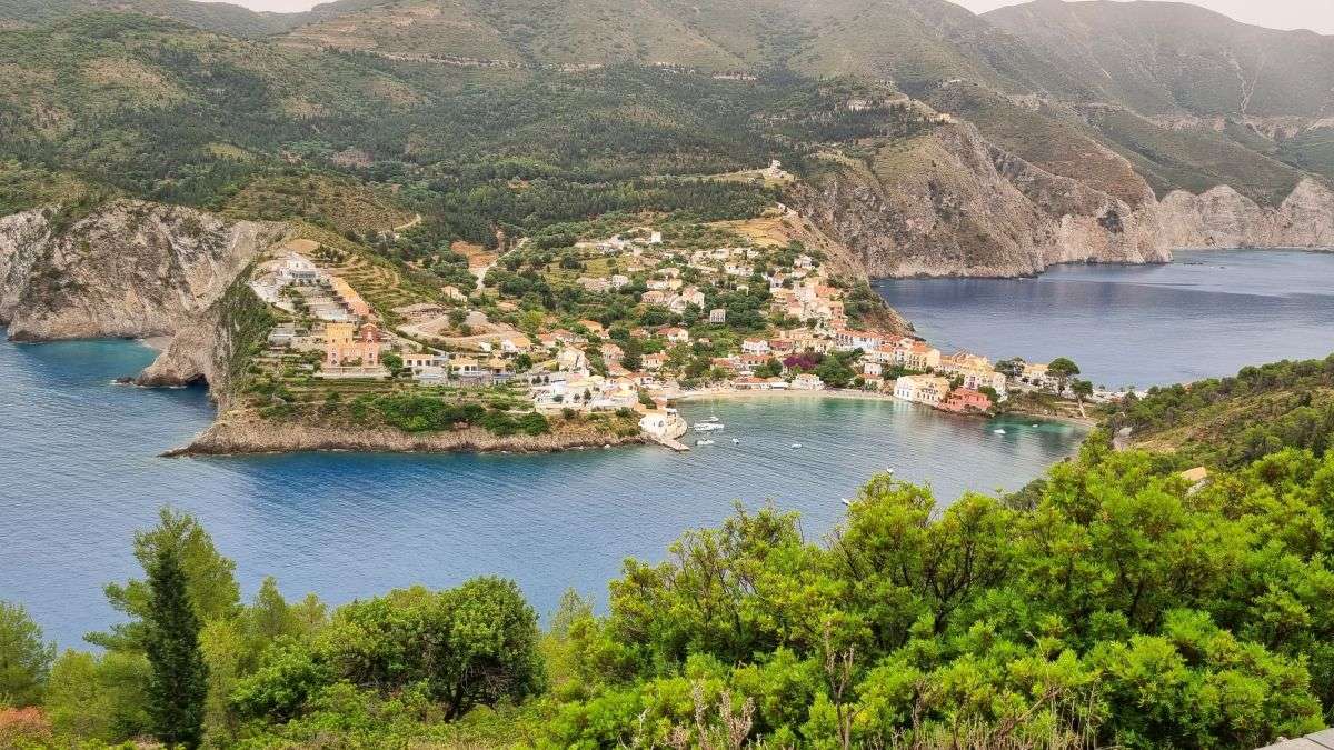 הכפר הציורי אסוס עם הבתים הצבעוניים על רקע המפר. הכחול והעצים