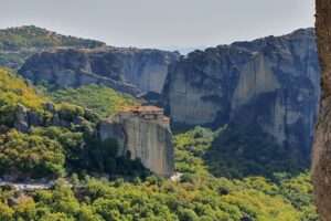 הנוף עוצר הנשימה של מנזרי מטאורה, תלויים מתחת לשמיים בין יערות ירוקים ומצוקי ענק
