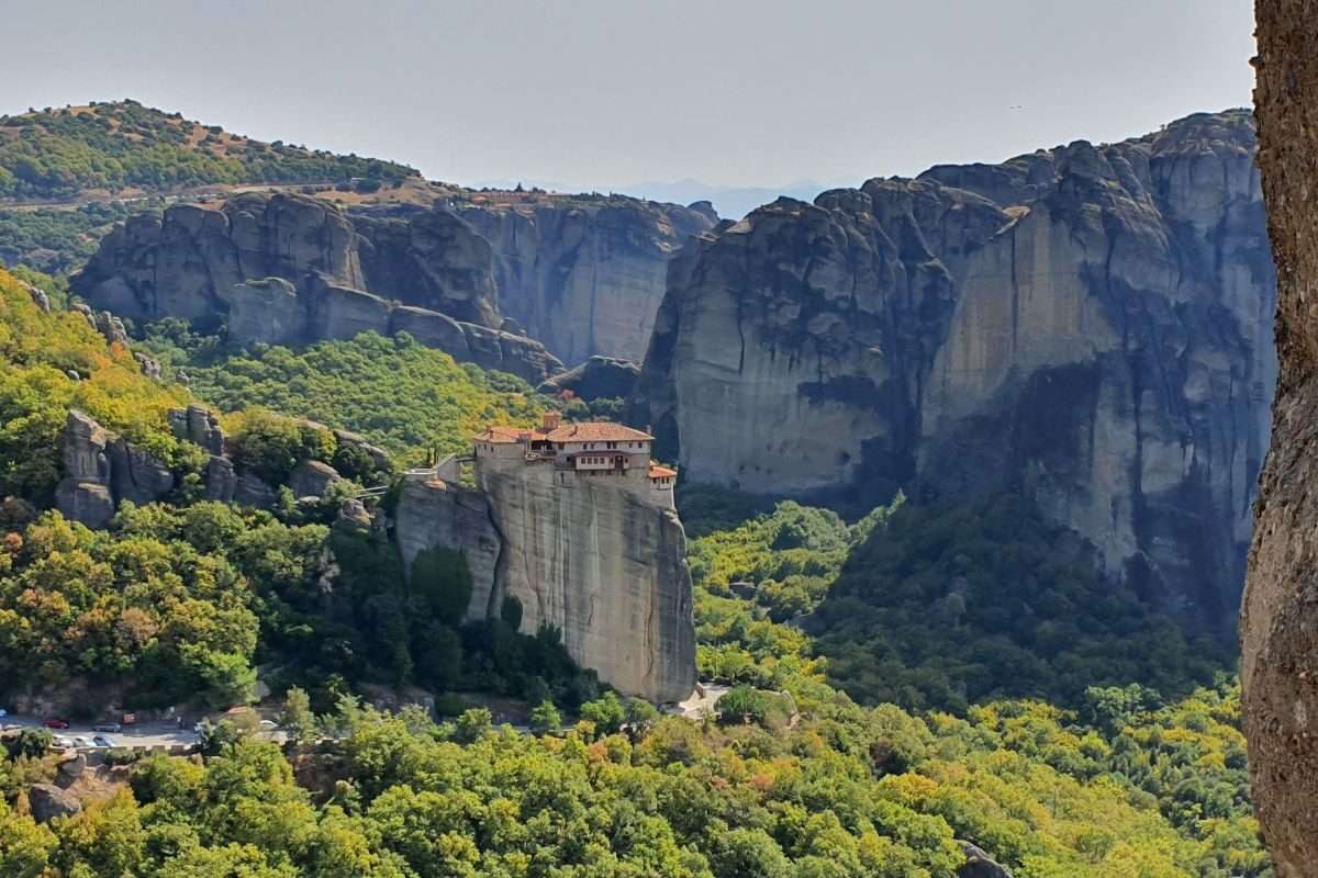 הנוף עוצר הנשימה של מנזרי מטאורה, תלויים מתחת לשמיים בין יערות ירוקים ומצוקי ענק