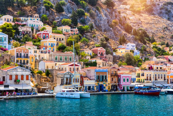 View of the beautiful greek island of Symi (Simi) with colourful houses and small boats. Greece, Symi island, view of the town of Symi (near Rhodes), Dodecanese.
