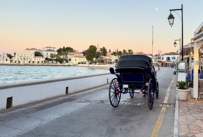 Spetses island, Greece. Horse carriage rear view and promenade at old historic town