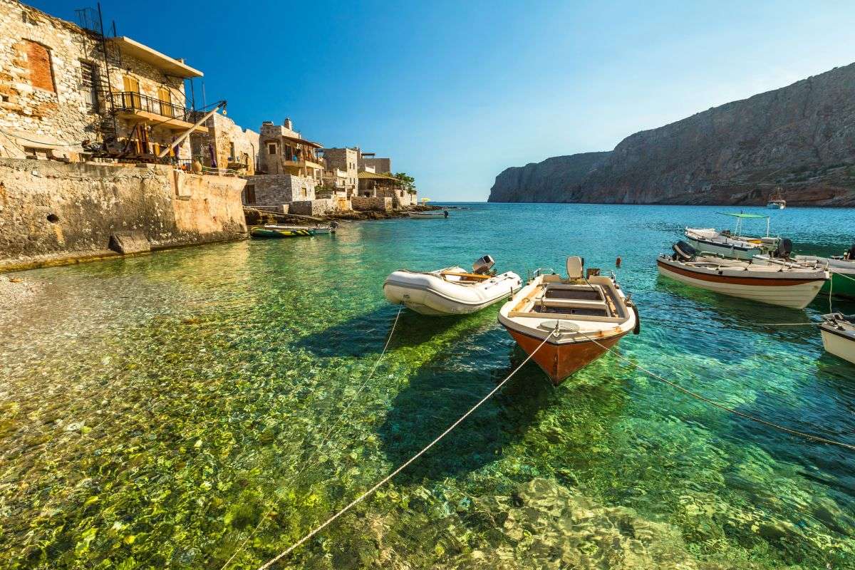 סירות דייגים קטנות מתנדנדות במים הצלולים של מפרץ גרולימנאס, בחבל המאני דרום הפלופונס.