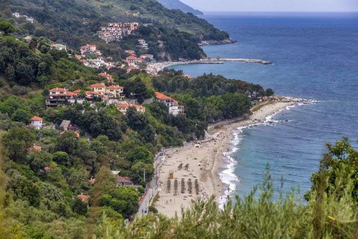 מבט פנורמי מלמעלה על רצועת חוף פאפא נרו (Papa Nero) בפיליון, יוון, עם מי טורקיז וצוקים מיוערים