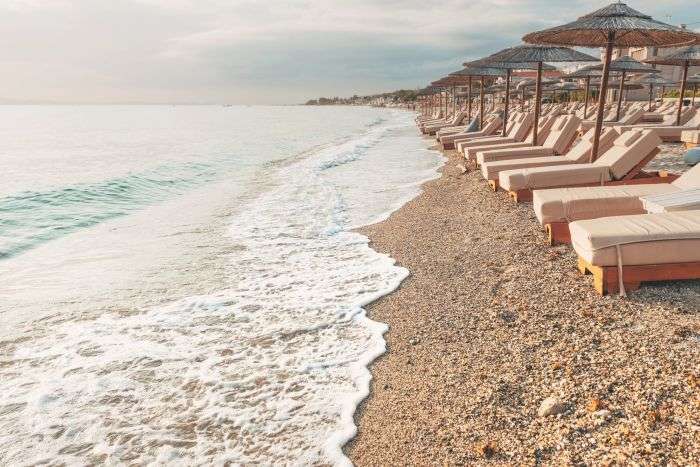 Beach beds with umbrellas at Polychrono seaside at Halkidiki, Greece