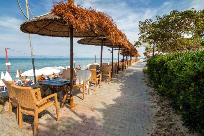 Sunny street cafe at the coast of Mediterranean sea in Hanioti village, Halkidiki