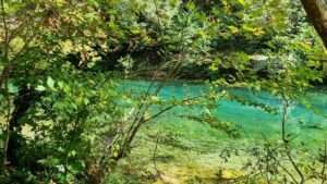 נהר הוידומטיס המרהיב בזגוריה, חבל אפירוס, עם מי טורקיז צלולים וקרים ושפע של צמחיה ירוקה מסביב